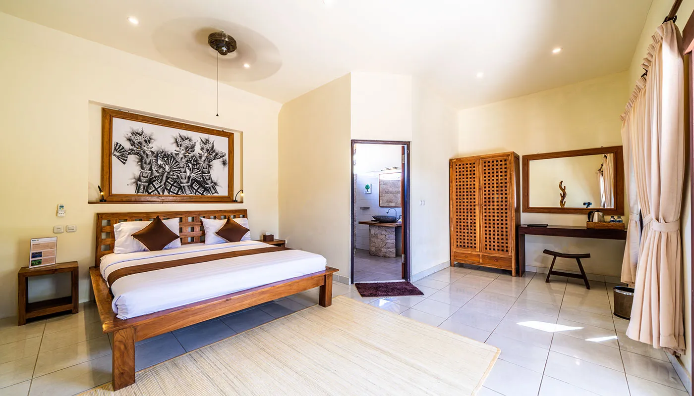 Bright Ocean Sun Resort bungalow with a wooden double bed in Tulamben